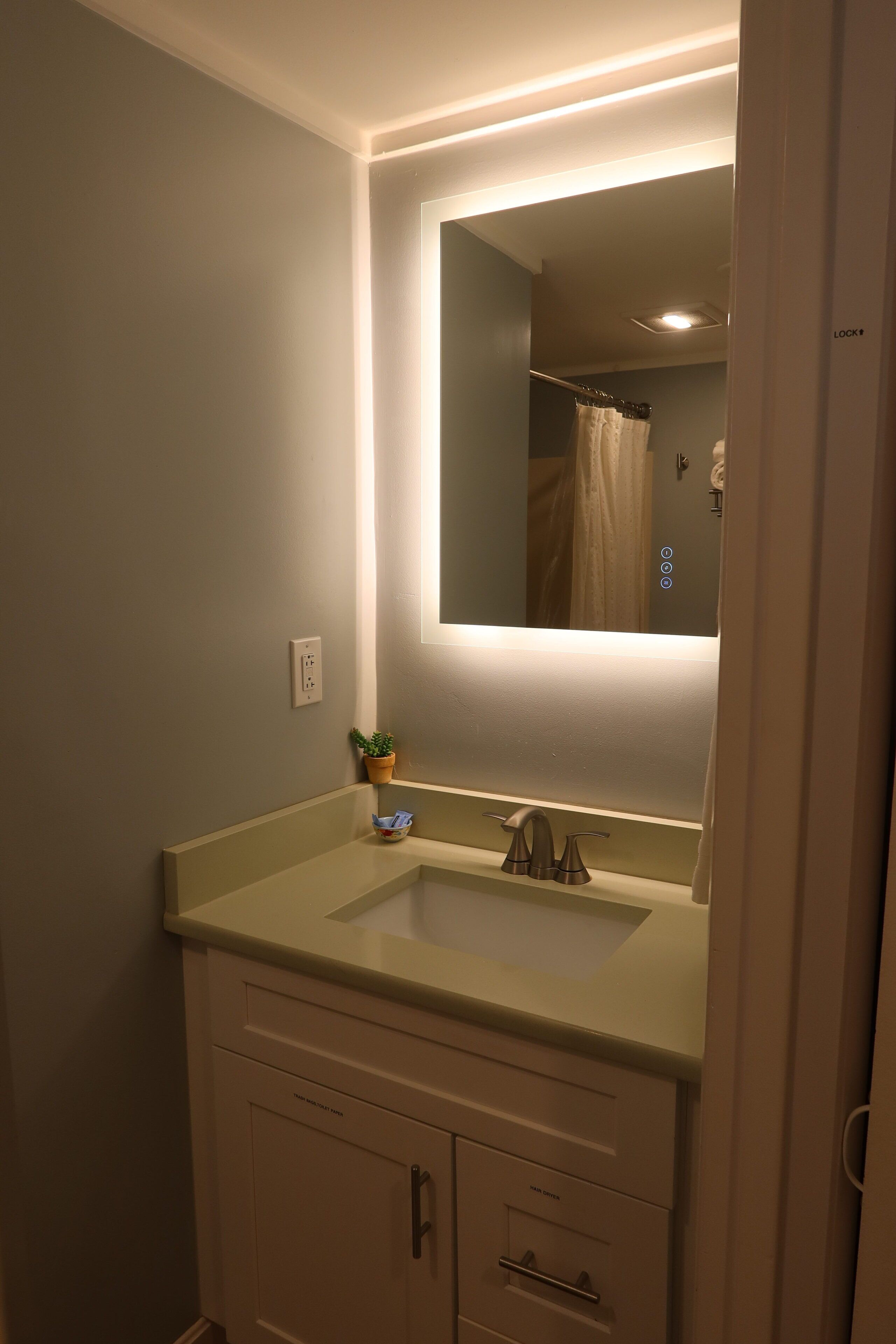 Een bad/douchecombinatie, een haardroger, handdoeken, zeep