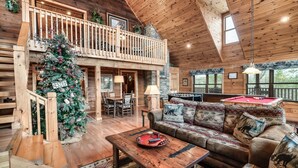 A spacious log cabin interior with a wooden staircase, a Christmas tree, a pool table, and a cozy seating area. - WHEELCHAIR ACCESSIBLE, 4 King Suites, Close to Pigeon Forge, WOW Views! (Sevierville)