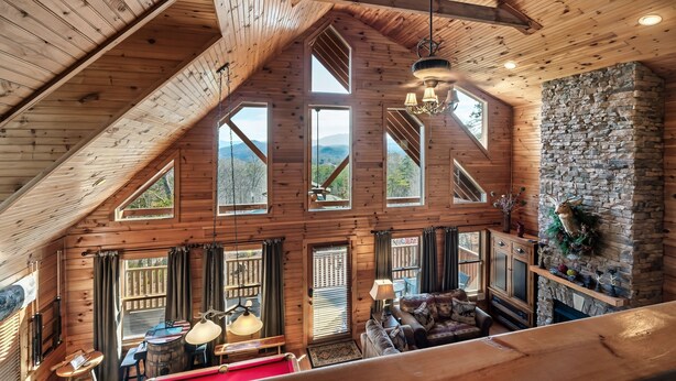 A spacious loft-style room with high ceilings, large windows, and a stone fireplace. - WHEELCHAIR ACCESSIBLE, 4 King Suites, Close to Pigeon Forge, WOW Views! (Sevierville)