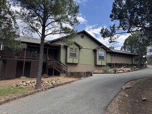 A two-story building with a covered porch and a garage. - Come Stay at Life`s a Hoot (Ruidoso)
