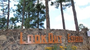 A stone wall with the text "LOOK OUT ESTATES" in large letters. - Come Stay in Antlers - D4 (Ruidoso)