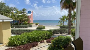 A view of a beach resort with a clear sky, palm trees, and a building with a blue roof.