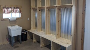 A bathroom with a wooden vanity, a sink, and a window with a plaid curtain. - Quiet country getaway located within 10 minutes from town (Pratt)