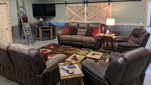 A living room with a brown leather sofa set, a wooden coffee table, and a patterned rug. - Quiet country getaway located within 10 minutes from town (Pratt)