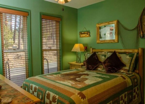 A bedroom with a bed, a nightstand, a lamp, and a window with blinds.