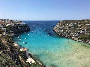 A coastal town with a clear blue sea, rocky cliffs, and buildings along the shore. - Modern apartment with a fantastic view Vistamar 2 (Cala en Porter)