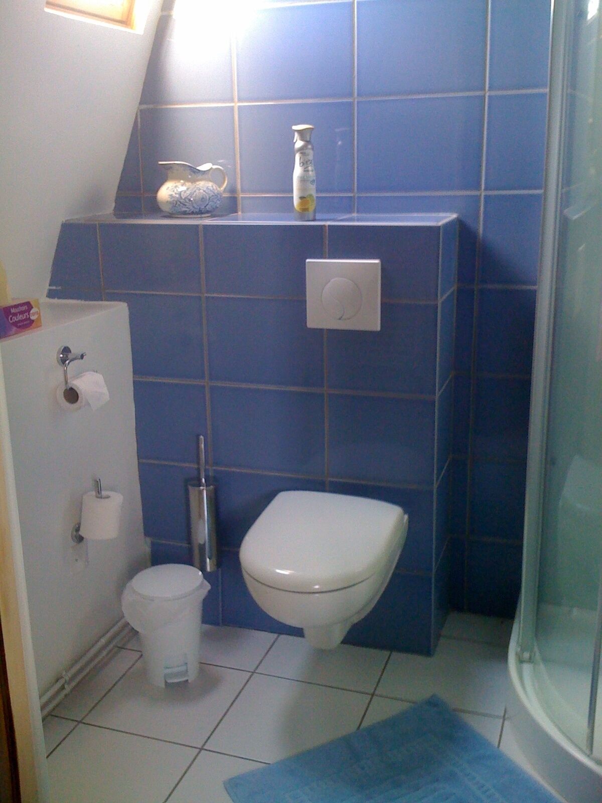 Casa de banho com sanita, bidé, secador de mãos e porta-toalhas.