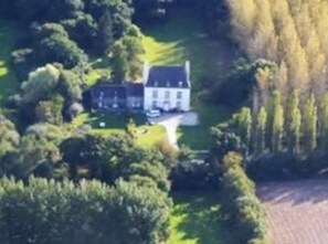 An aerial view of a large estate with multiple buildings, surrounded by dense greenery and trees. - Malouinière des Trauchandières Saint-Malo (Saint-Jouan-des-Guerets)