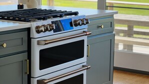 A kitchen with a built-in stove and oven, a window with a view of a green field, and a wooden floor. - RARE Beachfront AND Wildlife Reserve Home in Broadkill Beach! (Milton)