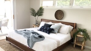 A bedroom with a wooden bed frame, white bedding, a blue throw blanket, and a small side table with a plant. - RARE Beachfront AND Wildlife Reserve Home in Broadkill Beach! (Milton)