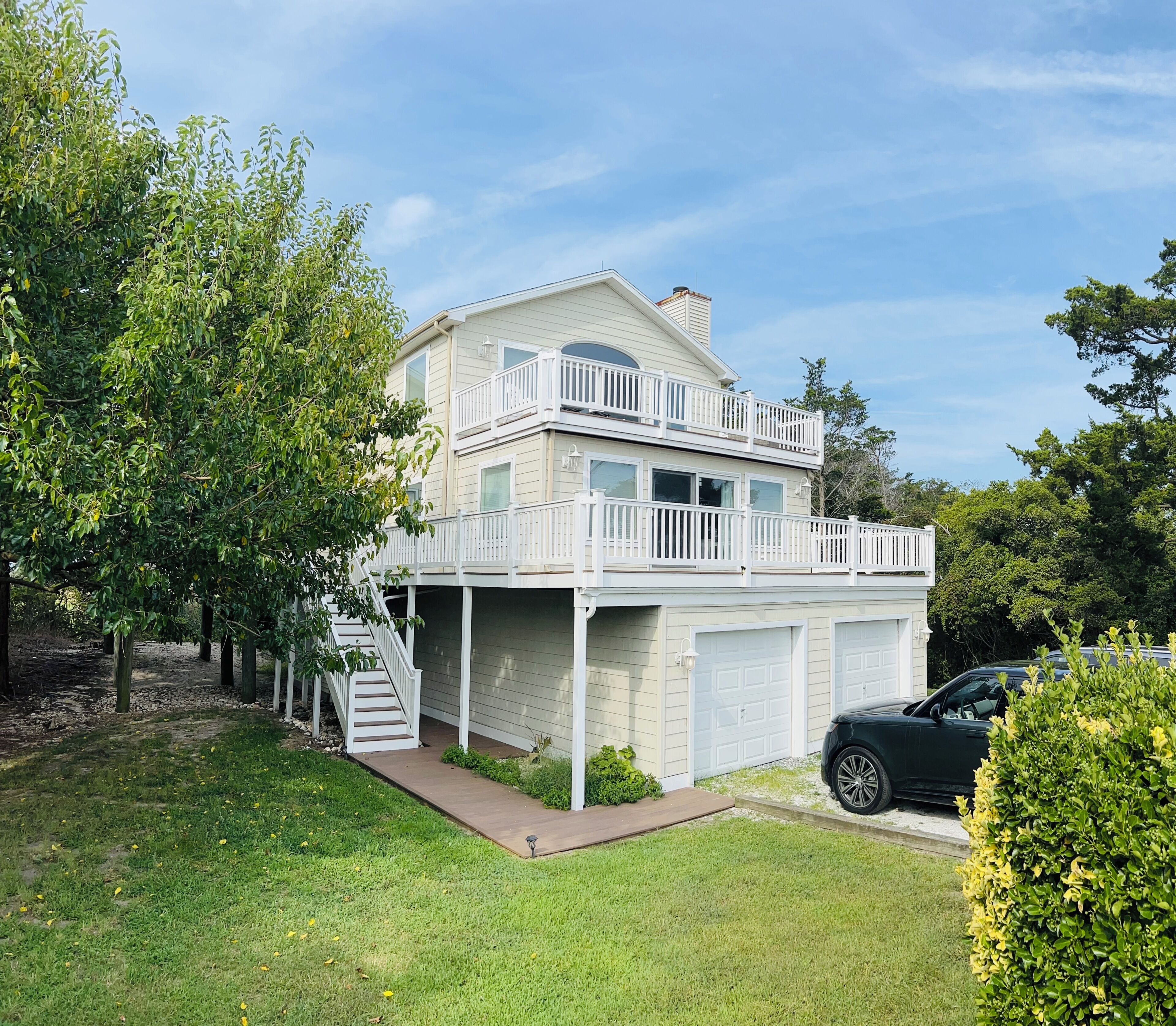 A two-story house with a balcony, a garage, and a driveway.