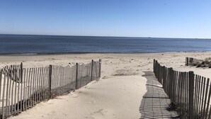 A sandy beach with a wooden fence leading to the water. - RARE Beachfront AND Wildlife Reserve Home in Broadkill Beach! (Milton)