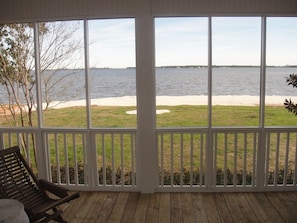 Enjoy a serene view of the beach and sea from this room's large window.