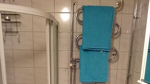Een badkamer met een douche, toilet en wastafel.