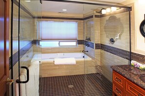 Een bad/douchecombinatie, een bubbelbad, een haardroger, handdoeken