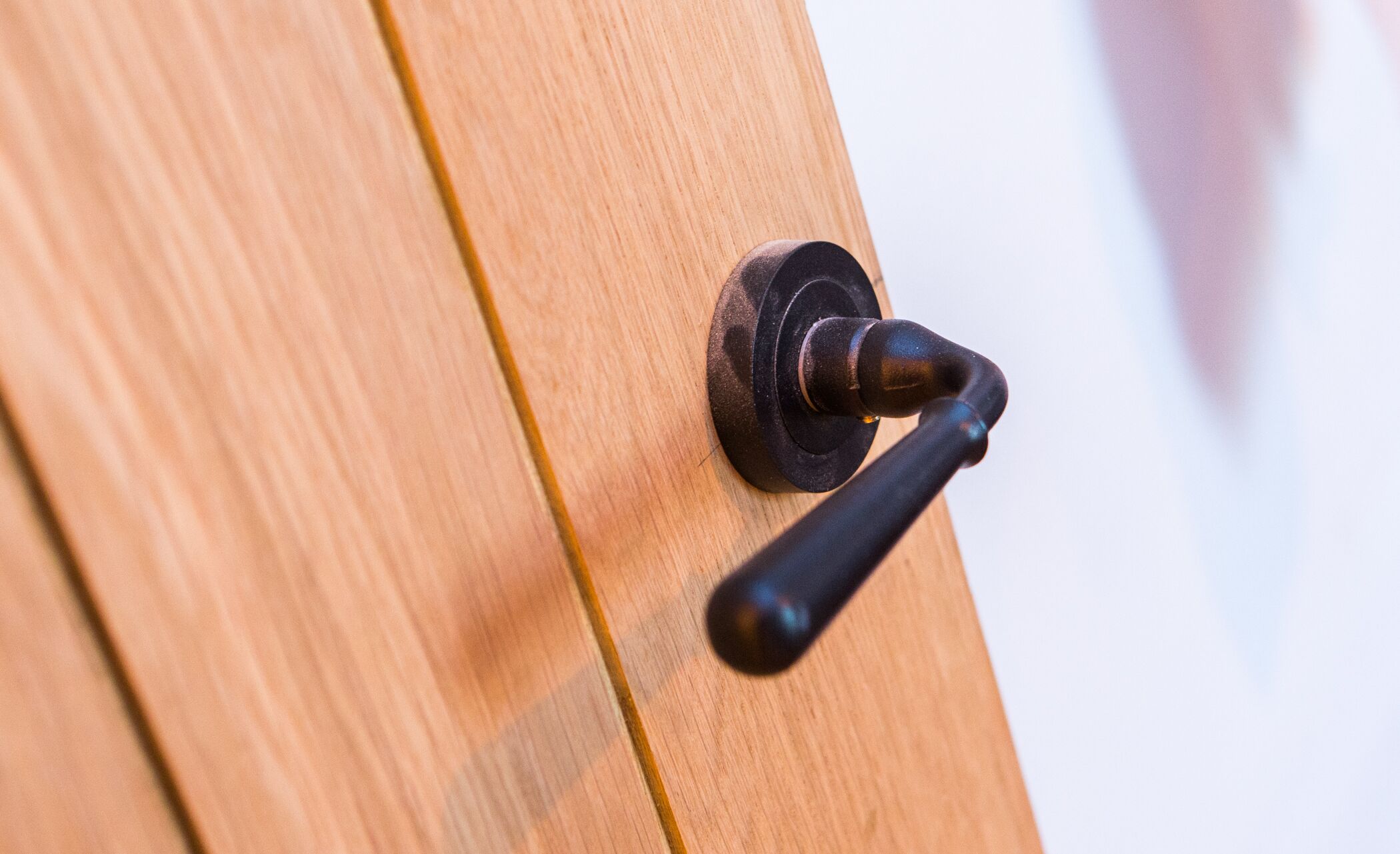 A wooden door with a black door handle.