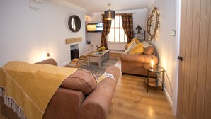 Una sala de estar acogedora con sofá, una mesa de centro y una chimenea.