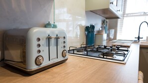 Una cocina con un tostador de estilo vintage y una estufa a gas.