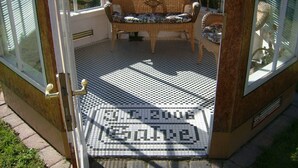 A porch with a checkered floor, a bench, and a door with a brass handle. - Pure enjoyment of nature on the Werra Valley Cycle Path (Ebenshausen)