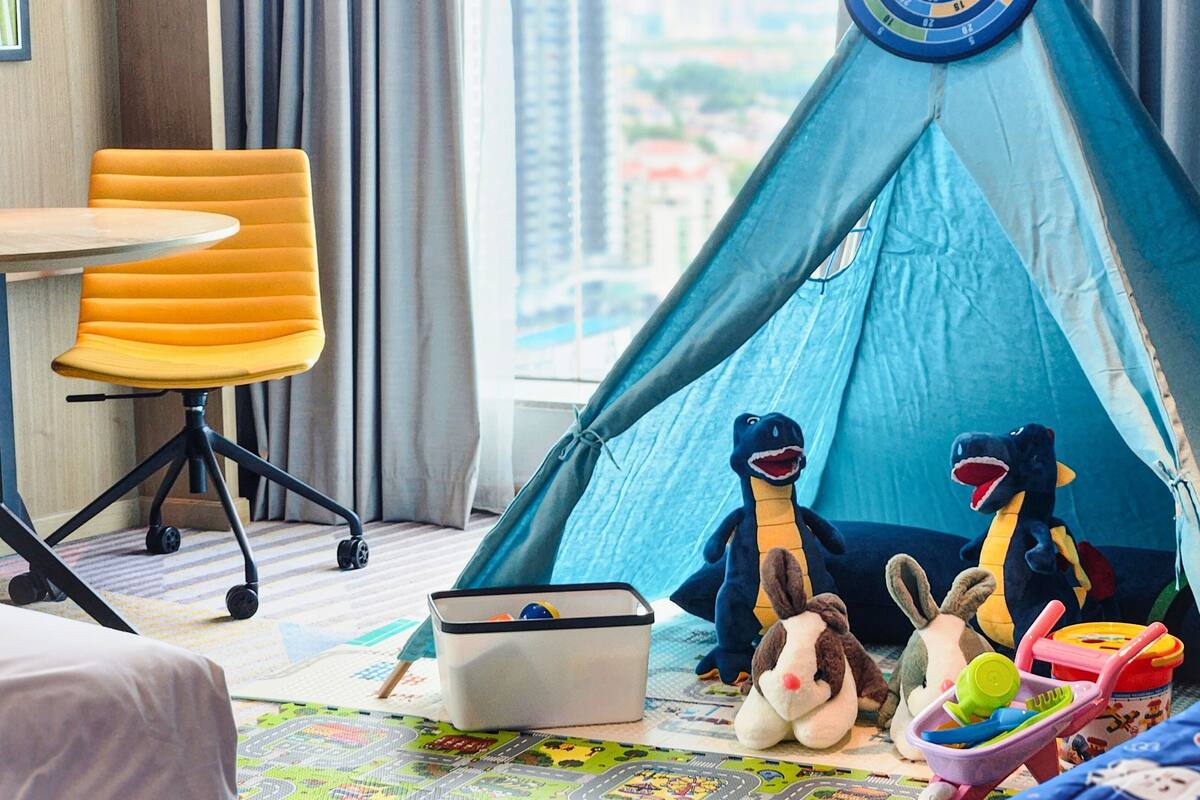 A room with a blue tent, a yellow chair, and various toys.
