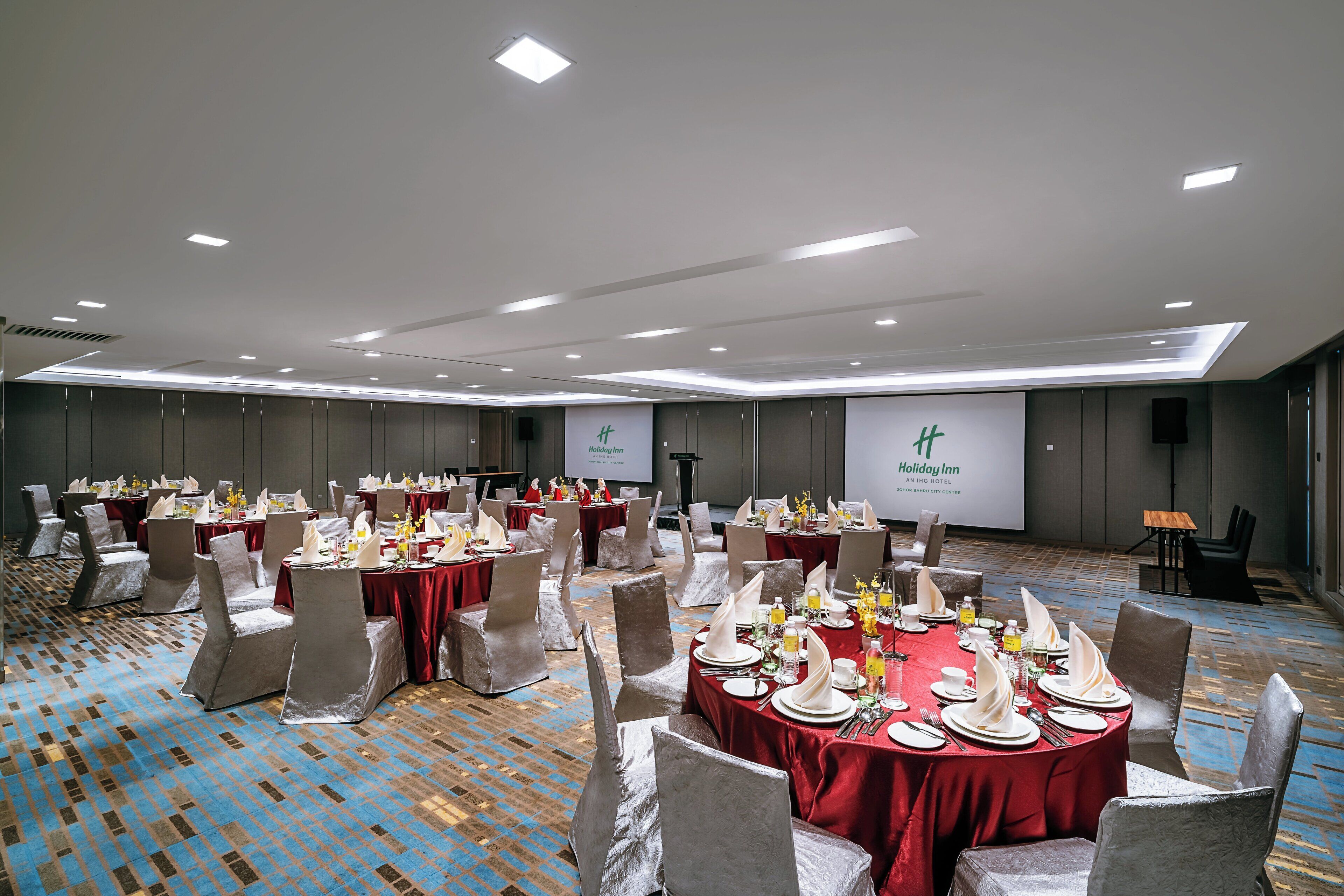 A banquet hall with round tables set for a formal event, featuring a consistent layout and neutral decor.