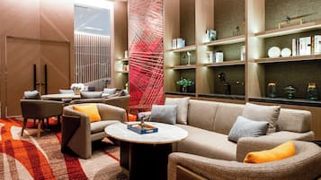 A modern living room with a sofa set, a coffee table, and a bookshelf.