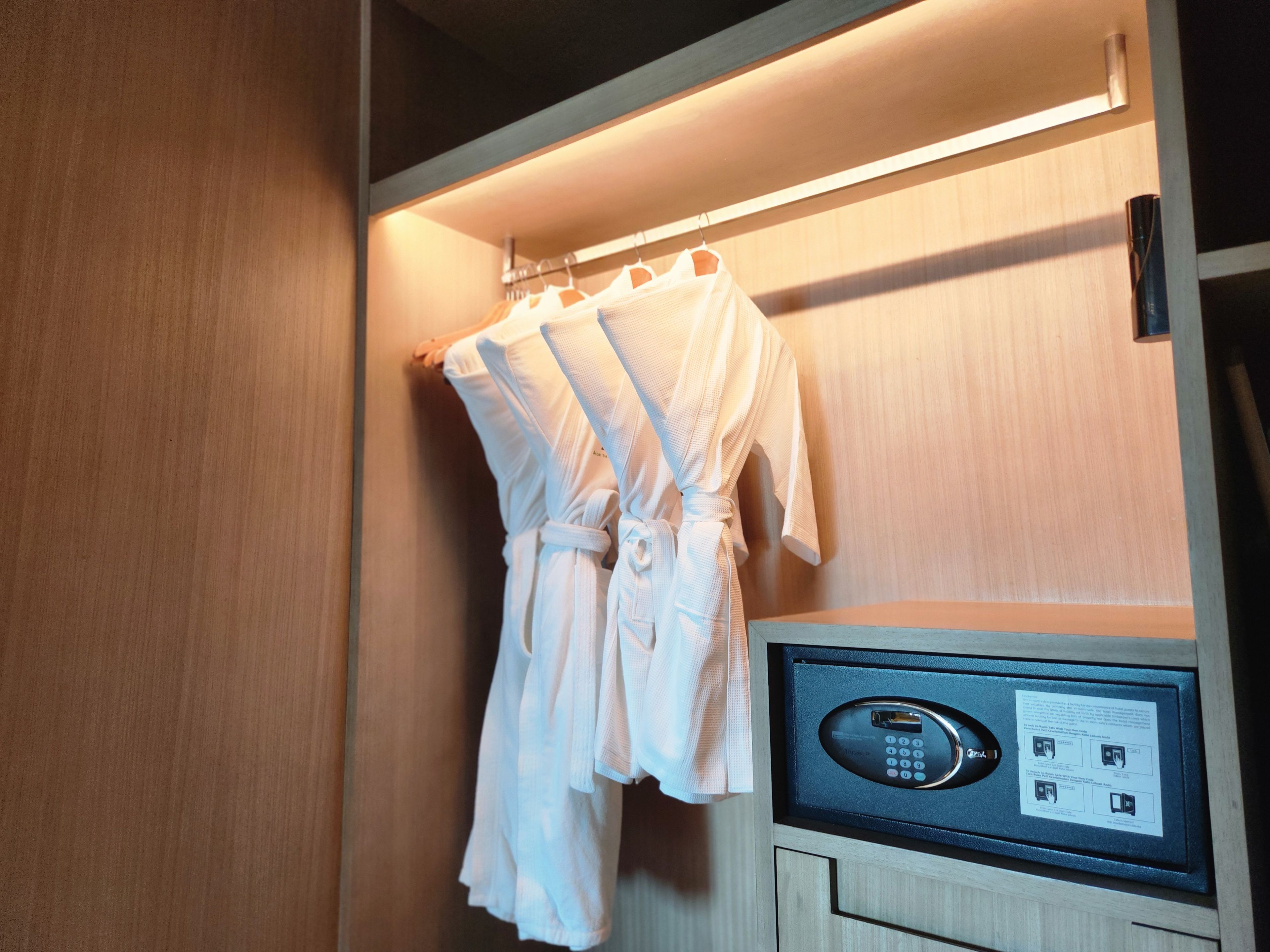 Un armario de madera con cerradura electrónica integrada y espacio para colgar ropa.