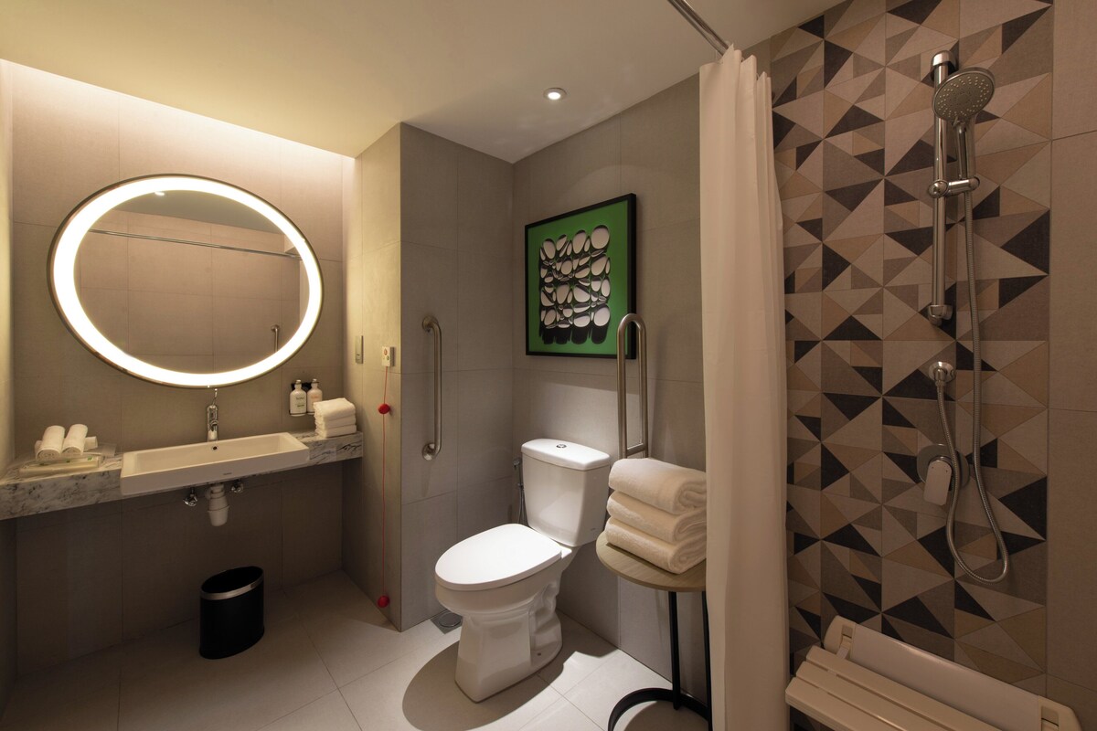 A modern bathroom with a toilet, sink, and shower.