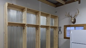 Een keuken met houten kastjes, een koelkast en een opgehangen herten schedel.