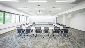 A conference room with a long table and chairs, large windows, and a carpeted floor. - Inn at Villanova University (Wayne)