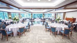 A large conference room with round tables and chairs, large windows, and a polished floor. - Inn at Villanova University (Wayne)