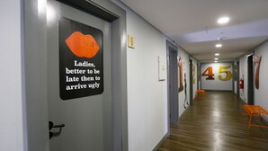 A hallway with a sign on the wall, a number '45' on the wall, and a fire extinguisher. - Hi Setubal Pousada de Juventude - Hostel (Setubal)