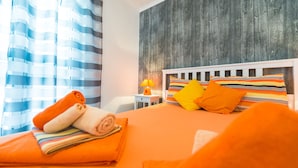 Ein Hotelzimmer mit gestreifter Bettdecke, einem Holzkopfteil und einem Nachttisch mit Lampe.