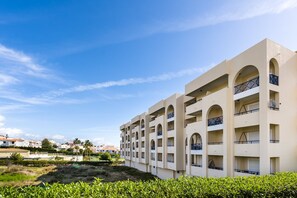 Un hôtel à plusieurs étages, doté de balcons et de fenêtres en arc de cercle.