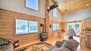 A cozy cabin interior with a fireplace, wooden walls, a dining area, and a large window. - Experience Yellowstone magic, just 27 mins away
A.C.  Sleeps 10+ (Island Park)
