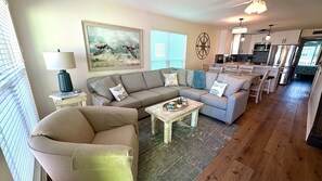 Un salon avec un canapé, une table basse et un tableau représentant des tortues de mer.