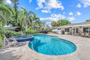 A backyard with a swimming pool, outdoor furniture, and a covered patio area. - Blu Sky Cottage | Waterfront Pool Home, Resort-Style Backyard, Near Siesta Key Village (Siesta Key)