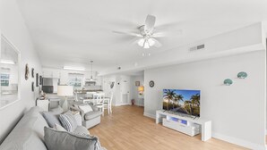 A modern living room with a flat-screen TV, grey sofas, and a wooden floor. - A Slice Of Paradise! Beautiful Ocean Views And Just Steps From The Beach (Panama City Beach)