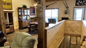 A rustic interior with wooden furniture, a dining area, and a mounted animal head.