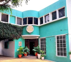 A hotel named "Hotel Don Felipe Restaurante" with a curved facade, multiple windows, and potted plants in front.