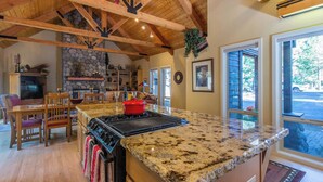 A kitchen with granite countertops, a red pot, and a stone fireplace.