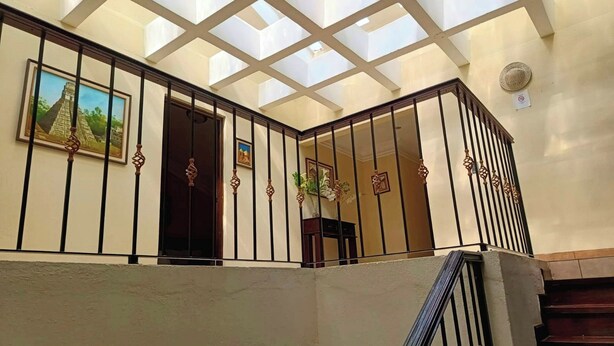 Una escalera con techo de vidrio y barandillas de metal.