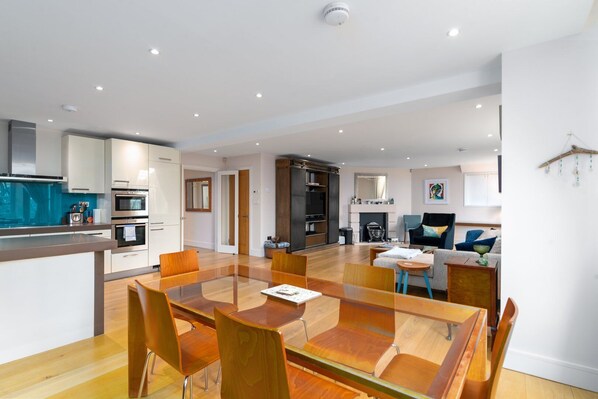 A modern apartment with a kitchen, dining area, and living room.