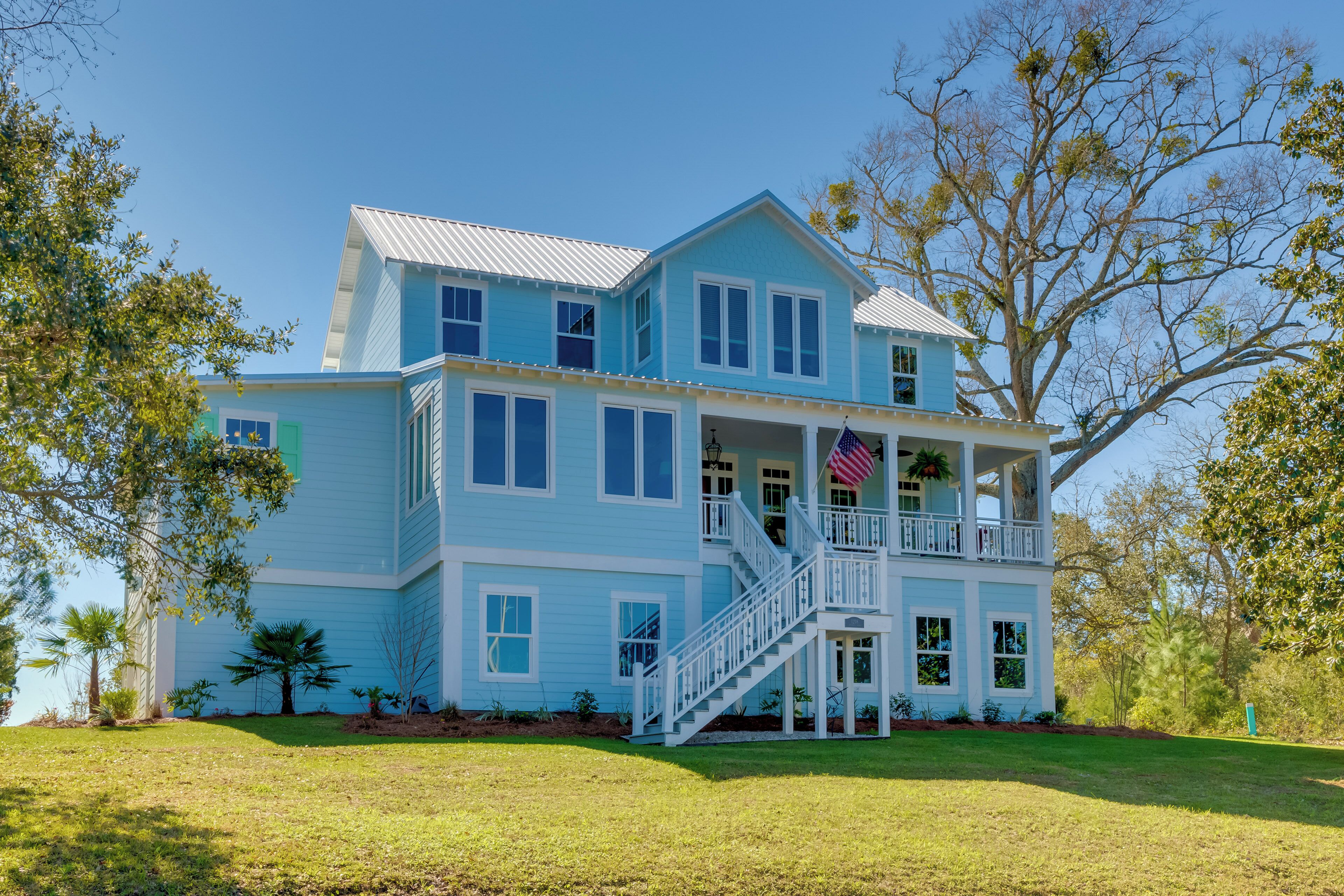 A two-story house with a balcony, a staircase, and a flag.