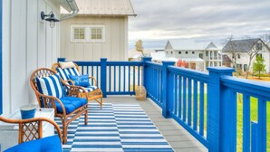 A balcony with wicker furniture and a blue-striped rug. - Carlton Landing! Gorgeous Home on Redbud Park (Carlton Landing)