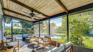 A covered patio with wooden furniture, a ceiling fan, and a view of a backyard swimming pool. - 'Uncle Louie's' Gulf Coast Gem w/ Outdoor Oasis (Bradenton)