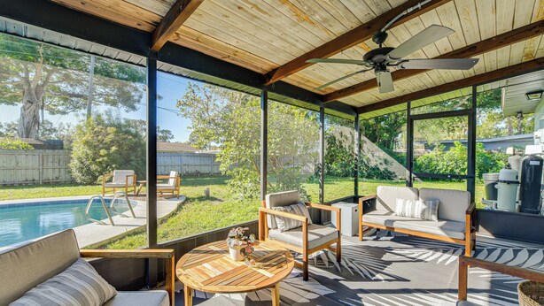 A covered outdoor patio with a pool, seating area, and a ceiling fan. - 'Uncle Louie's' Gulf Coast Gem w/ Outdoor Oasis (Bradenton)