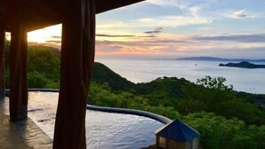 A view from a covered outdoor area overlooking a body of water with distant landforms. - Casita Cole (Sardinal)