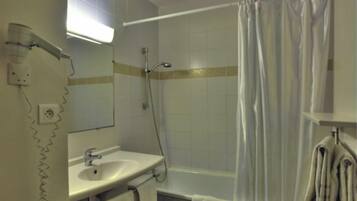 Een badkamer met een douche, een wastafel en een handdoekhouder.