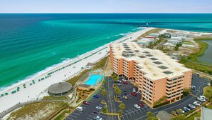 A coastal hotel with a swimming pool, beach access, and a parking lot. - Steps to Private Beach! Heated pool-tennis-picklebal-shuffleboard. (Destin)